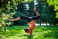 Yoga. Young woman practicing yoga or dancing or stretching in nature at park. Handstand. Health lifestyle concept