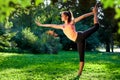 Yoga. Young woman practicing yoga or dancing or stretching in nature at park. Health lifestyle concept