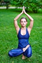 Yoga. Young woman practicing yoga meditation in nature at the park. Health lifestyle concept