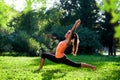 Yoga. Young woman practicing yoga or dancing or stretching in nature at park. Health lifestyle concept