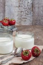 yoghurt in a glass and a bucket with fresh strawberries on a woo Royalty Free Stock Photo