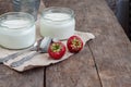 yoghurt in a glass and a bucket with fresh strawberries on a woo Royalty Free Stock Photo