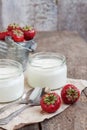 yoghurt in a glass and a bucket with fresh strawberries on a woo Royalty Free Stock Photo