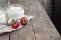 Yoghurt in a glass and a bucket with fresh strawberries on a woo Royalty Free Stock Photo