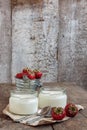 yoghurt in a glass and a bucket with fresh strawberries on a woo Royalty Free Stock Photo