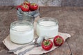 yoghurt in a glass and a bucket with fresh strawberries on a woo Royalty Free Stock Photo
