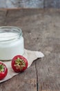 yoghurt in a glass and a bucket with fresh strawberries on a woo Royalty Free Stock Photo