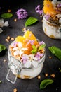 Yoghurt with granola, orange, mint and edible flowers Royalty Free Stock Photo