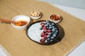 Yoghurt in green plate with blueberries, raspberries and chia seeds on the white table lined with a beige tablecloth Royalty Free Stock Photo