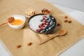 Yoghurt in green plate with blueberries, raspberries and chia seeds on the white table lined with a beige tablecloth Royalty Free Stock Photo