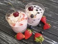 Yoghurt, strawberry, cherry, blueberry glass on a black wooden background