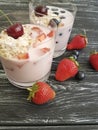 Yoghurt, strawberry, cherry, morning cereal homemade muesli blueberry glass on a black wooden background