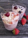 Yoghurt, strawberry, cherry, morning cereal muesli blueberry glass on a black wooden background