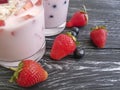 Yoghurt, strawberry, cherry, morning cereal sweet homemade muesli blueberry glass on a black wooden background