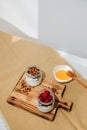 Yoghurts in glass jars with blueberries, raspberries and chia seeds and granola on a wooden board with tablecloth Royalty Free Stock Photo