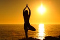 Yogi exercising yoga at sunset on the beach