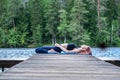 Yogi girl practicing yoga, Reclining Hero exercise, Virasana pose on the lake. The concept of appeasement, healthy