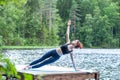 yogi  girl  practicing yoga, Side Plank exercise, Vasisthasana pose on the lake. The concept of appeasement,  healthy Royalty Free Stock Photo