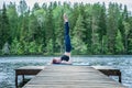 Yogi  girl  practicing yoga, standing in Salamba Sarvangasana exercise, supported Shoulder stand pose on the lake.  Concept Royalty Free Stock Photo