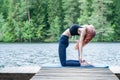 Yogi  girl  practicing yoga, stretching in Ustrasana exercise, Camel pose,  on the lake. Concept of healthy life and natural Royalty Free Stock Photo