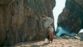 Yogi girl standing upside down on sand rocky Ursa beach. Woman making yoga asana Royalty Free Stock Photo