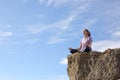 Yogi practicing yoga in the top of a cliff