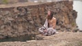 Yogi sitting on the rock near the sea