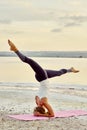 Yogi woman practising yoga outdoors doing Salamba Sirsasana asana