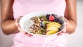 Yogurt, blackberry muesli, raspberries, blueberries, kiwi and peaches in a white bowl holding young woman Royalty Free Stock Photo