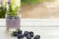 Yogurt Blue Berry and fresh berry on wooden white table on background outdoor view.Close up.