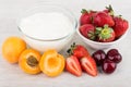 Yogurt, bowl with strawberries, pieces of apricots and cherries Royalty Free Stock Photo