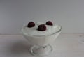 Yogurt with cherries in a glass bowl on a wooden surface. Royalty Free Stock Photo