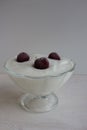 Yogurt with cherries in a glass bowl on a wooden surface. Royalty Free Stock Photo