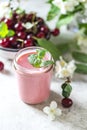 Yogurt with cherry, mint and and fresg berries on a light concrete background. Summer healthy dessert with berries