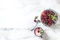 Yogurt with cherry, mint and and fresg berries on a light concrete background. Summer healthy dessert with berries