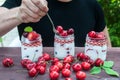 Yogurt with Cherry and strawberries, square. Berries of blueberries and strawberries are scattered on the table.