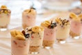 Yogurt dessert with different fruits, crushed cookie and chocolate, presented in crystal glasses decorated with floral elements