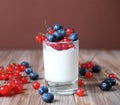 yogurt with fresh berries in glass jar, on wooden background Royalty Free Stock Photo