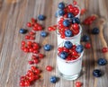 yogurt with fresh berries in glass jar, on wooden background Royalty Free Stock Photo