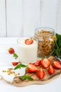 Yogurt, fresh ripe strawberry, granola - dietary dish on a white wooden table. Proper nutrition. Royalty Free Stock Photo