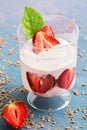 Yogurt with fresh strawberries in a glass on a blue background. Selective focus. Summer dessert with strawberries. Royalty Free Stock Photo