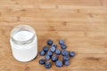 Yogurt in glass jar and blueberries on a wooden background. Royalty Free Stock Photo