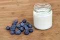 Yogurt in glass jar and blueberries on a wooden background. Royalty Free Stock Photo
