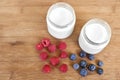 Yogurt in glass jar, raspberries and blueberries on a wooden background - directly above Royalty Free Stock Photo