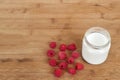 Yogurt in glass jar and raspberries on a wooden background. Royalty Free Stock Photo