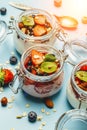 Yogurt with granola, fresh berries and nuts in a jar on a blue background. Healthy breakfast and dessert milk concept Royalty Free Stock Photo