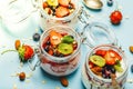 Yogurt with granola, fresh berries and nuts in a jar on a blue background. Healthy breakfast and dessert milk concept Royalty Free Stock Photo