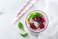 Yogurt granola parfait with frozen raspberries, coconut flakes and chia seeds, layered dessert or breakfast. Selective focus. Top