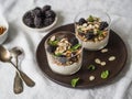 Yogurt with granola, walnut, dates, blackberries and mint in glass glasses on a wooden plate on a white tablecloth Royalty Free Stock Photo