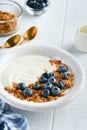 Yogurt. Greek Yogurt with granola and fresh blueberries in white bowl over old white wood background. Morning breakfast concept. H Royalty Free Stock Photo